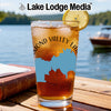 Glass of iced tea with "Diamond Valley Lakes California" design, on a table by a lake.