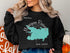 Black sweatshirt with a teal Manasquan Reservoir map and "NEW JERSEY" text.
