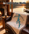 Woven blanket with Lake Glenville map and compass design on sofa.