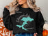 Black sweatshirt with Silverwood Lake map and compass design.