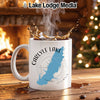 White mug with Carlyle Lake Illinois map and compass, steam rising.