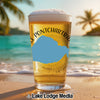 Glass of beer with "Lake Pontchartrain" text on a beach with palm trees.