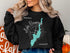 Black sweatshirt with "Beautiful Lake Bomoseen Vermont" and a compass rose graphic.