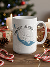 White mug with Sanibel Island Florida map and compass on a wooden surface with holiday decorations.