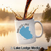 White mug with Hauser Lake Idaho design and splashing coffee.