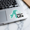 Teal sticker with "Dillon Life" text on a laptop keyboard.