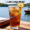 Glass with iced tea, lemon, and "Cherokee Lake" design, on a wooden table.