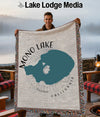 Woven blanket featuring a Mono Lake California map design held by a smiling man.