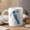 White mug with blue Pavlas Lake shape, compass, and Wisconsin text.