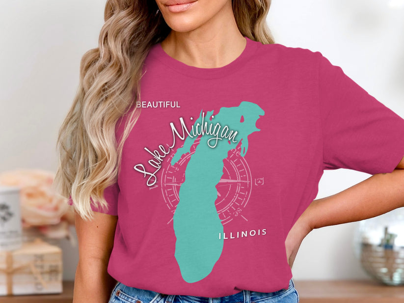 Turquoise outline of Lake Michigan with compass rose and "Beautiful Illinois" text on pink t-shirt.