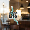 Cayuga Life text and outline of Cayuga Lake on a window.