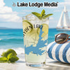 Glass with Hayden Lake map and compass design on a beach background.