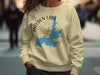 Light yellow sweatshirt with a blue Hayden Lake Idaho map and compass graphic.