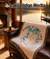 Blanket with Pomme de Terre Lake map and compass design on leather couch.