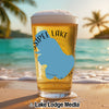 Glass of beer with blue lake outline, "Sipee Lake New Hampshire" text, and beach background.