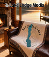 Keechelus Lake Washington map and compass throw blanket on a leather couch.