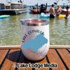 A white insulated wine tumbler with a Lake Quinault Washington map design rests on a wooden boat deck with people swimming in the lake behind it.