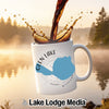 White mug with Glen Lake Michigan map and compass design with coffee pouring.