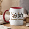 White mug with red interior and handle, featuring "Lake Life" design and "Manasquan Reservoir New Jersey".