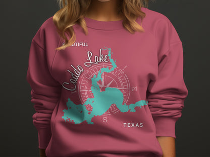 Pink sweatshirt with teal map of Caddo Lake and compass graphic.