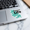 Teal sticker with "Webster Life" text on a laptop keyboard.