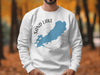 White crewneck sweatshirt with a blue outline of Sand Lake, Ontario, and compass graphic.