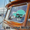Turquoise Mono Life sticker and Lake Lodge Media branding on a boat window.