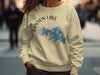 Light yellow sweatshirt with Canyon Lake, Texas map and compass graphic.