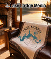 Tapestry blanket with Lake Monroe, Indiana map design on a brown leather couch.
