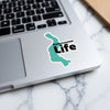 Sammamish Life sticker on a silver laptop keyboard with a marble background.