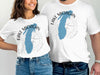 Couple wearing white t-shirts with Lake Michigan outline and compass design.