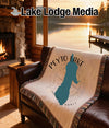 Tapestry blanket with Peyto Lake silhouette and compass design on a leather couch.