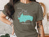 Turquoise Walden Pond outline and compass rose on a tan t-shirt.