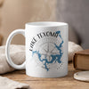 White mug with Lake Texoma map and compass graphic, emitting steam.