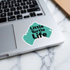 Turquoise sticker with text "Little Turtle Life" on a laptop.