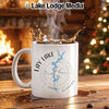 White mug with "Lay Lake Alabama" map and compass design, hot coffee splashing.