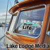 A sticker reading "Merwin Life" is on a boat window, with "Lake Lodge Media" text below.