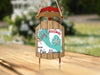 Sled ornament with "Merry Christmas From Lake Almanor" text, teal map background.