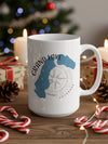 White mug with Grand Lake Colorado map and compass graphic, on a wooden table with pinecones and candy canes.