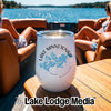 A white insulated wine tumbler with a Lake Minnetonka compass map graphic sits on a wooden boat table.