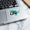 Siskiyou Life sticker in teal, shaped like the US, is placed on a laptop keyboard.
