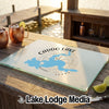 A glass cutting board featuring a blue map of Caddo Lake, Texas, on a wooden outdoor bar.