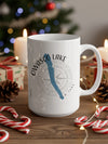 White mug with "Owasco Lake New York" and compass graphic, surrounded by Christmas decor.