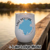 A white wine tumbler featuring a blue map of Lake Moultrie sits on a wooden dock at sunset.