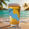 Glass of beer on beach with blue lake outline and "Sandhill Lake Wisconsin" text.