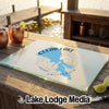 Clear Lake California glass cutting board resting on an outdoor wooden bar with copper mugs.