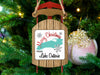 Sled ornament with "Merry Christmas From Lake Ontario" text hangs on a Christmas tree next to a bauble.
