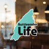 Teal sticker with "Rattlesnake Life" text on a window.
