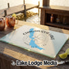 A rectangular glass cutting board featuring a Chautauqua Lake New York map design sits on a wooden outdoor bar.