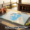 A glass cutting board featuring a blue map of Lake Casitas, California, on an outdoor wooden table.